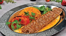 Bulgur pilavı ve közlenmiş domatesle Adana kebap